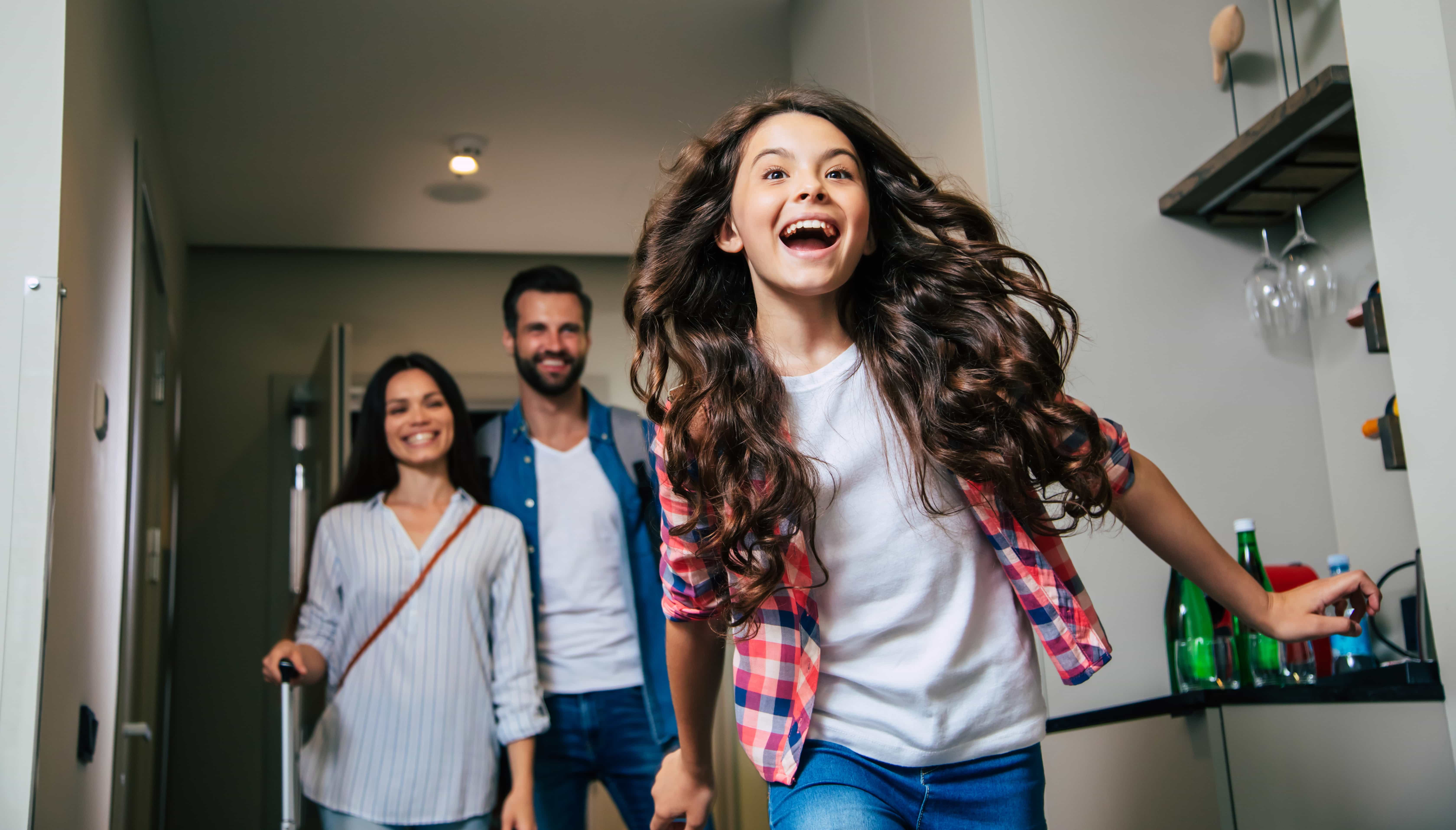 Beautiful happy excited family with a backpack and suitcases in modern hotel